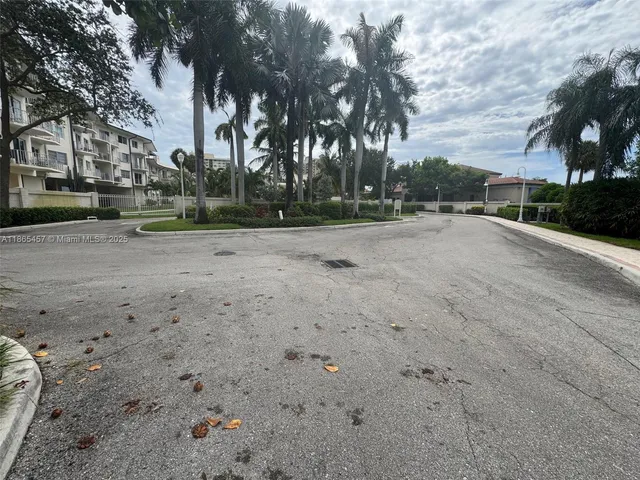 a view of dirt yard with large trees