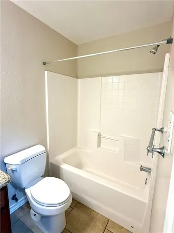 a white toilet sitting next to a bath tub