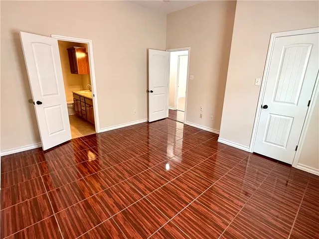 an empty room with wooden floor and closet