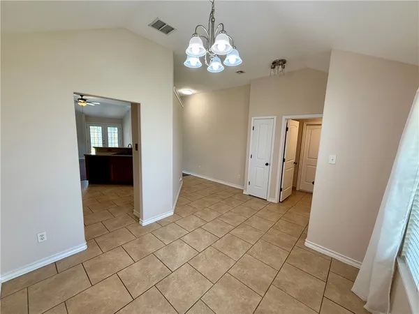 an empty room with closet and chandelier