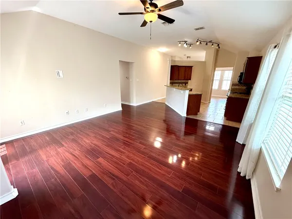 a view of a livingroom with furniture wooden floor and a ceiling fan