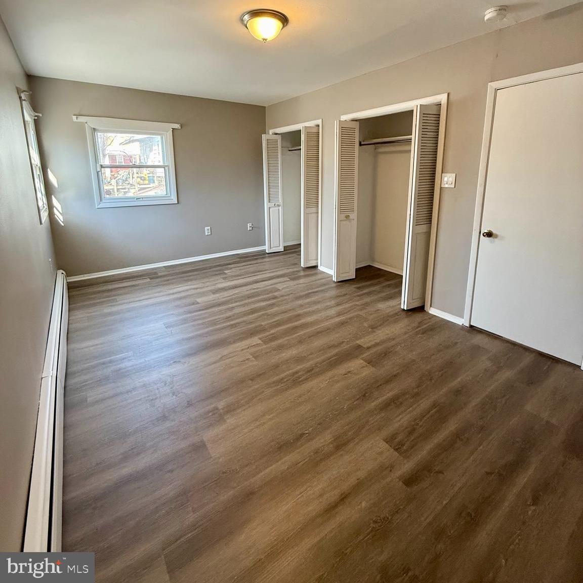 1643 Pennington Road Ewing, NJ 08618 - Photo 12 of 12 an empty room with wooden floor and windows