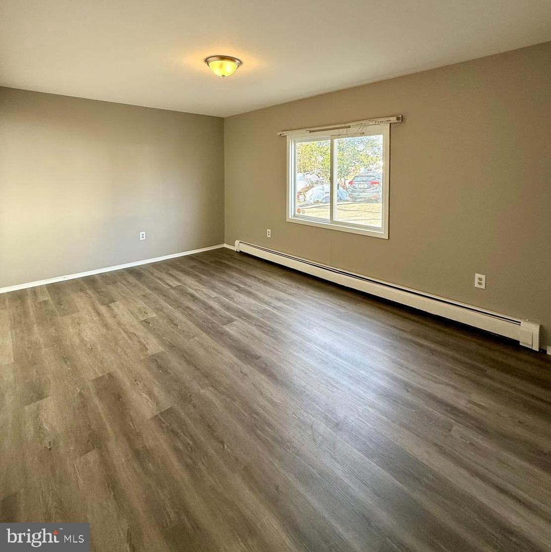 1643 Pennington Road Ewing, NJ 08618 - Photo 7 of 12 an empty room with wooden floor and windows