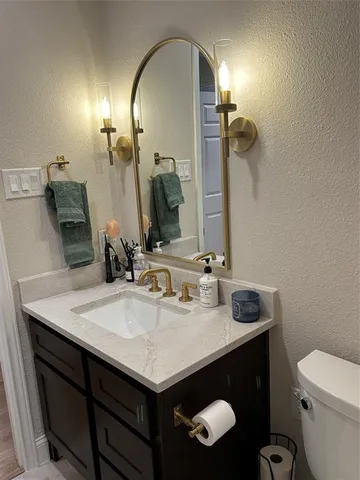 a bathroom with a sink a toilet and mirror