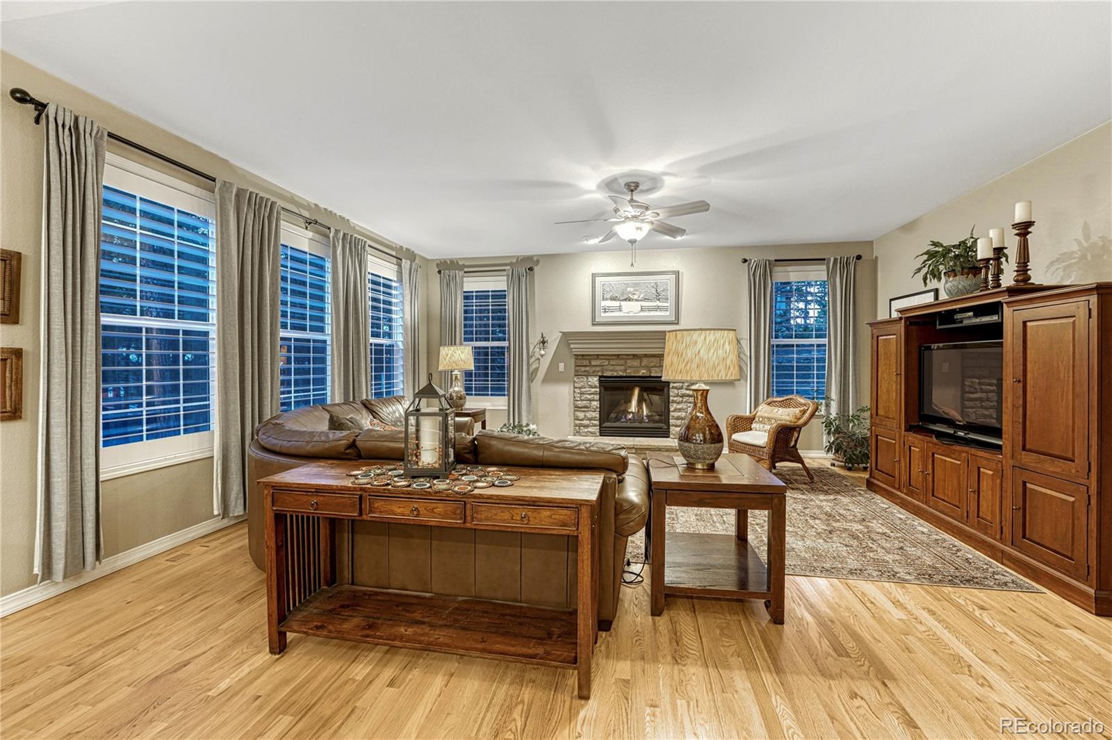 18150 Bakers Farm Road Colorado Springs, CO 80908 - Photo 11 of 49 a living room with furniture a fireplace and a flat screen tv