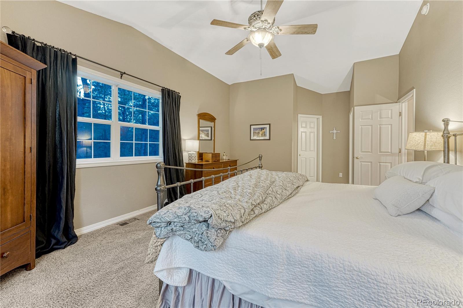 18150 Bakers Farm Road Colorado Springs, CO 80908 - Photo 20 of 49 a bedroom with a large bed and wooden floor