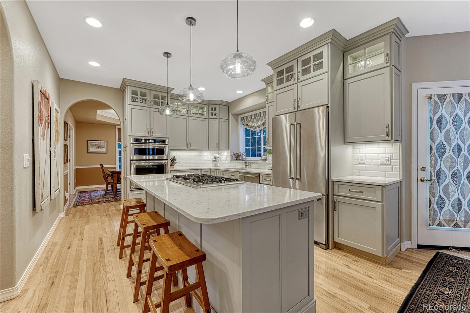 18150 Bakers Farm Road Colorado Springs, CO 80908 - Photo 6 of 49 a kitchen with stainless steel appliances granite countertop a refrigerator a oven a stove and a sink with wooden floor