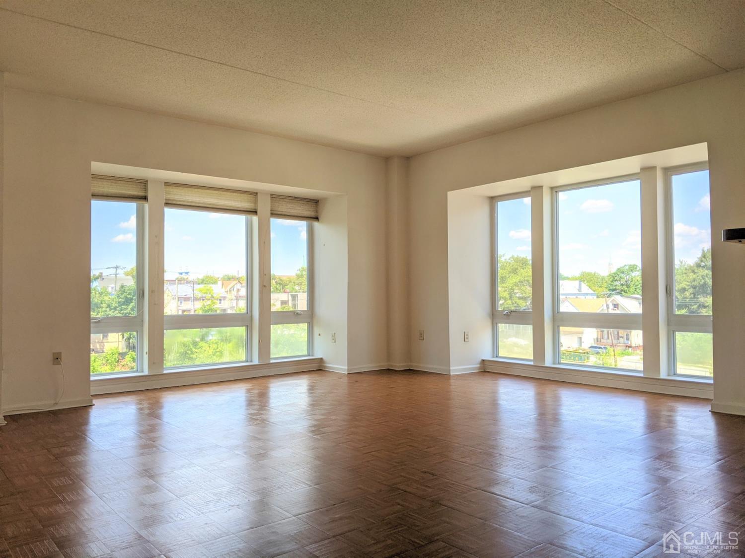 358 Rector Street, Unit 504 Perth Amboy, NJ 08861 - Photo 4 of 18 a view of an empty room with wooden floor and a window