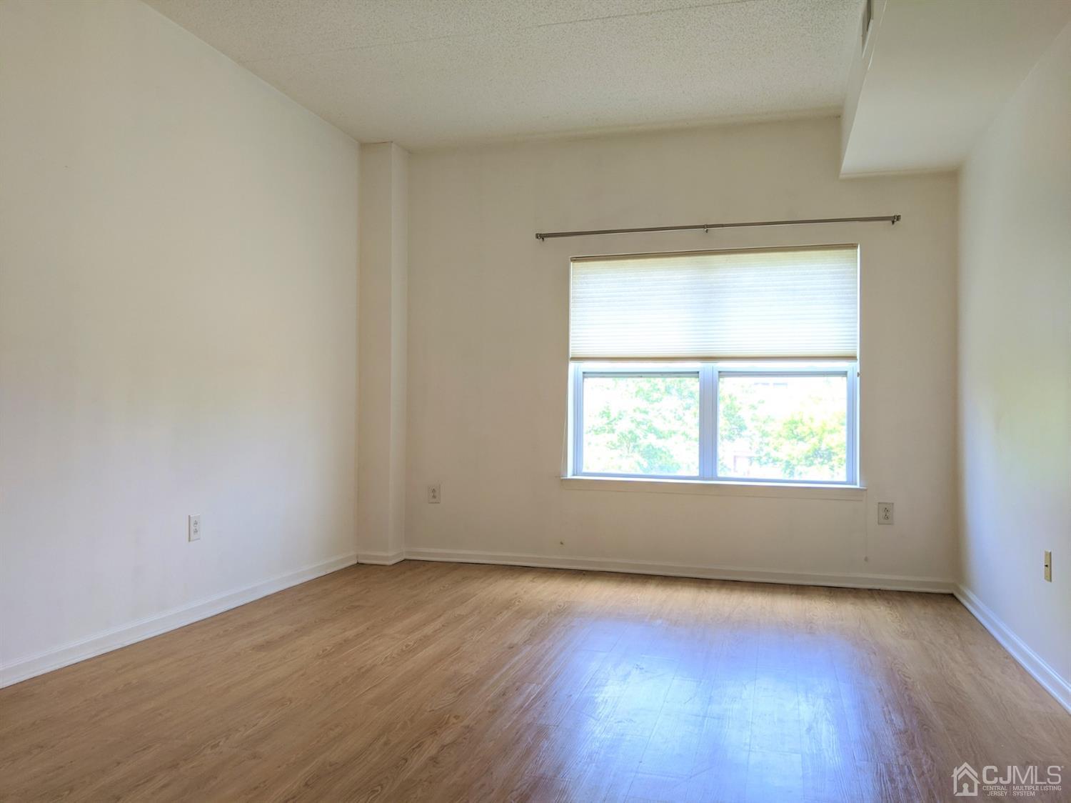 358 Rector Street, Unit 504 Perth Amboy, NJ 08861 - Photo 8 of 18 an empty room with wooden floor and windows