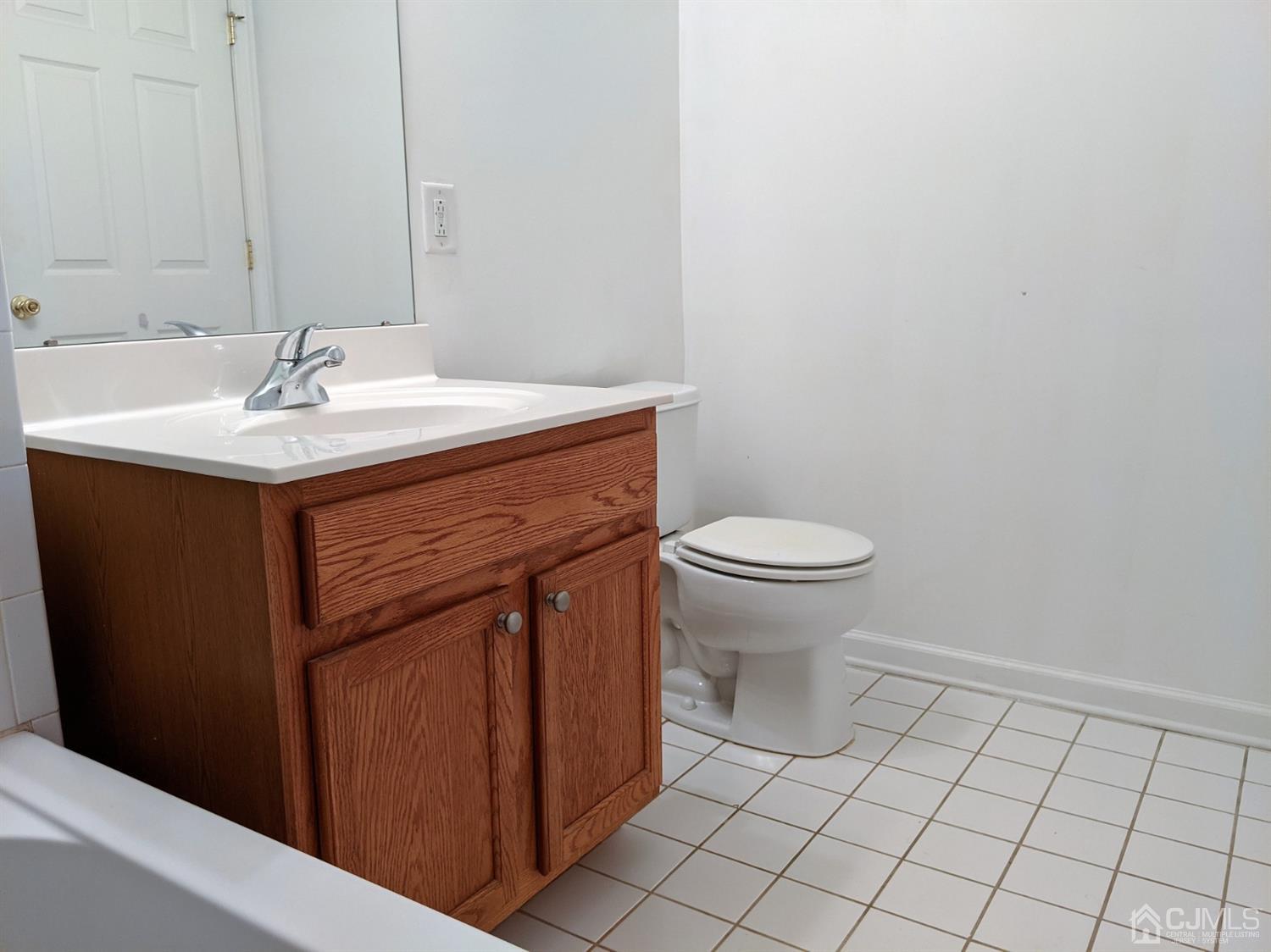 358 Rector Street, Unit 504 Perth Amboy, NJ 08861 - Photo 10 of 18 a bathroom with a sink toilet and a mirror