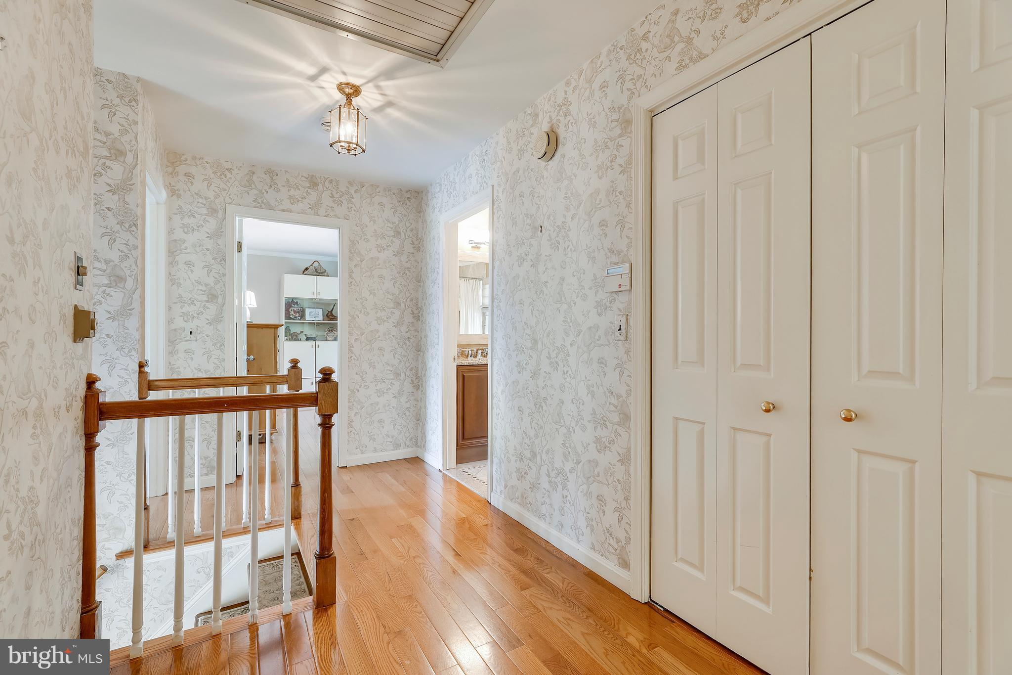 13402 Cambria Farms Road Phoenix, MD 21131 - Photo 20 of 28 a view of a hallway with wooden floor and a bathroom
