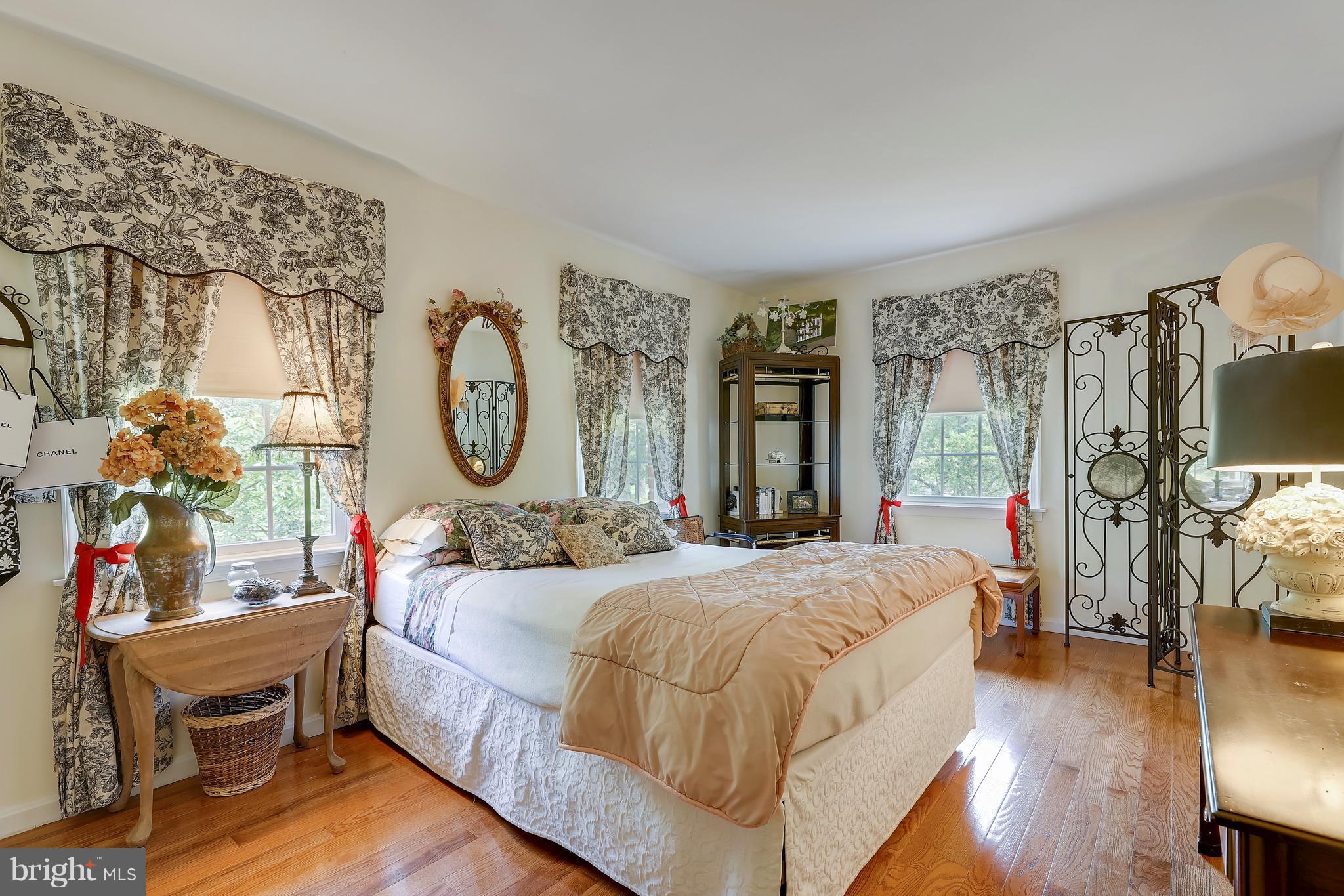 13402 Cambria Farms Road Phoenix, MD 21131 - Photo 27 of 28 a bedroom with a bed a mirror on dresser and a wooden floor