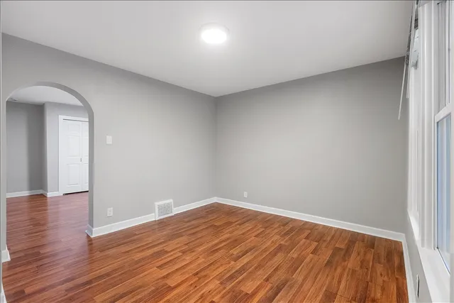 a view of empty room with wooden floor