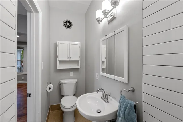 a bathroom with a toilet a sink and mirror