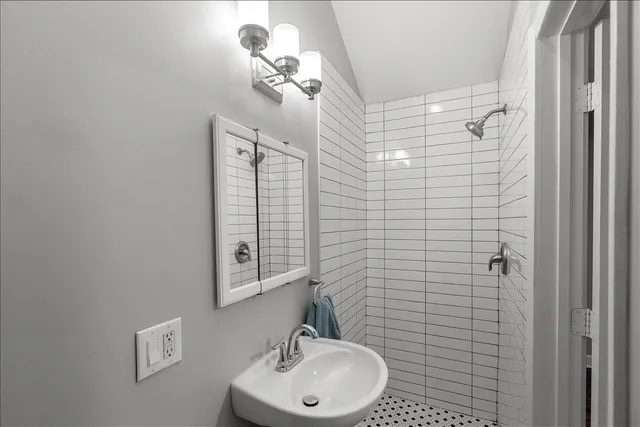 a bathroom with a sink a mirror and shower