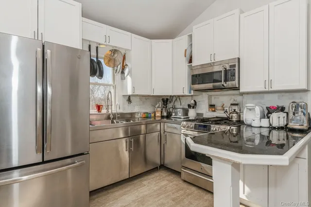 a kitchen with stainless steel appliances granite countertop a refrigerator sink and microwave
