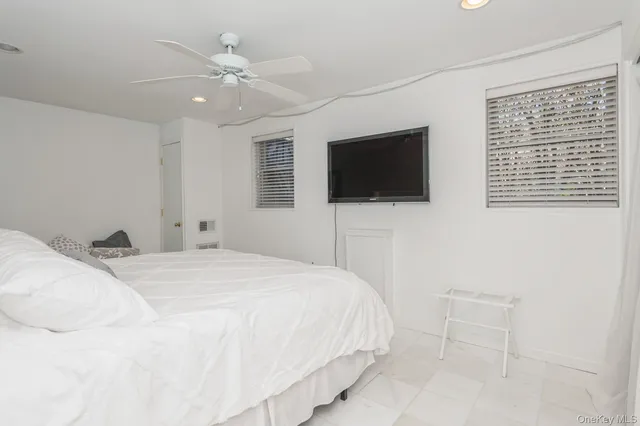 a bedroom with a bed window and a flat screen tv