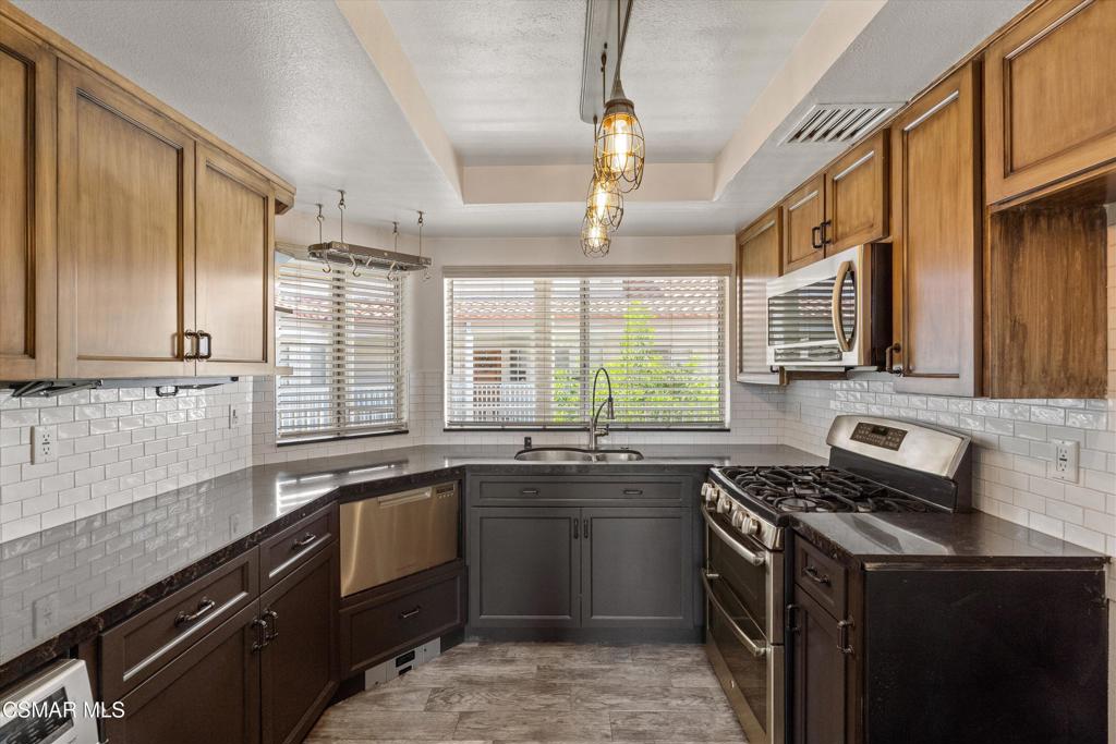 3306 Darby Street, Unit 402 Simi Valley, CA 93063 - Photo 6 of 31 a kitchen with stainless steel appliances a sink stove and cabinets