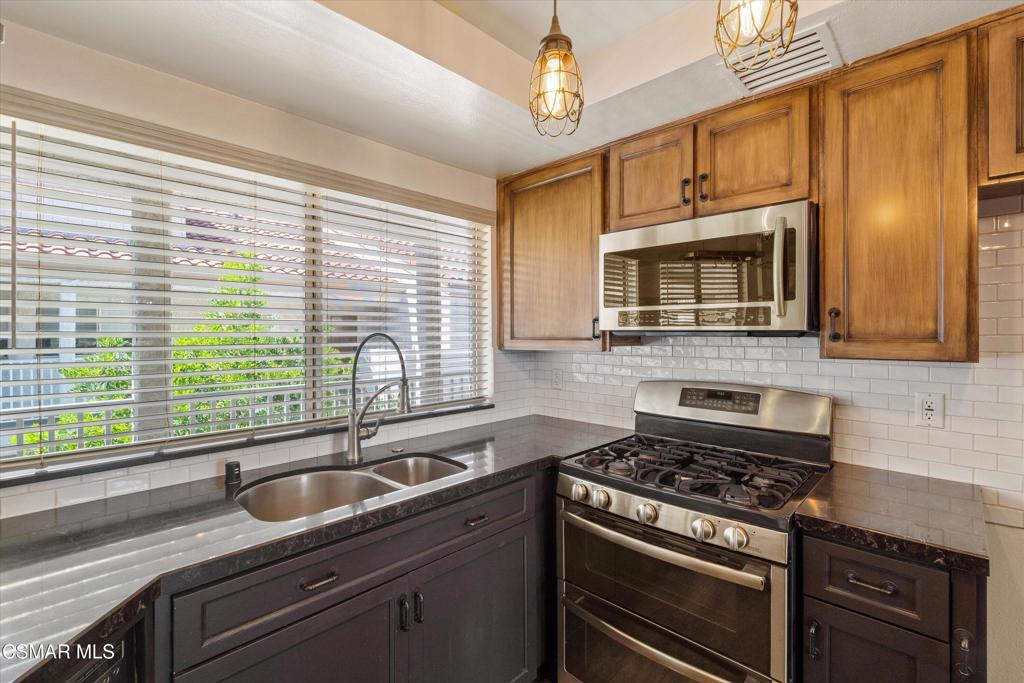 3306 Darby Street, Unit 402 Simi Valley, CA 93063 - Photo 7 of 31 a kitchen with stainless steel appliances granite countertop a sink stove and microwave