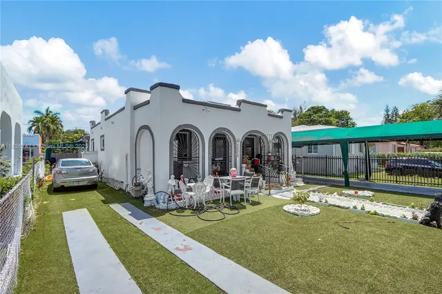a front view of a house with garden and sitting area