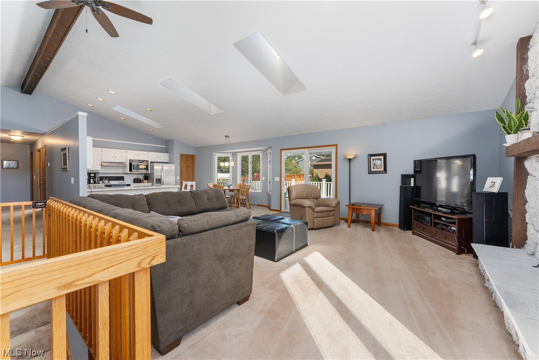 5226 Johnnycake Ridge Northeast Canton, OH 44705 - Photo 13 of 32 Living room with vaulted ceiling with skylight, light colored carpet, and ceiling fan