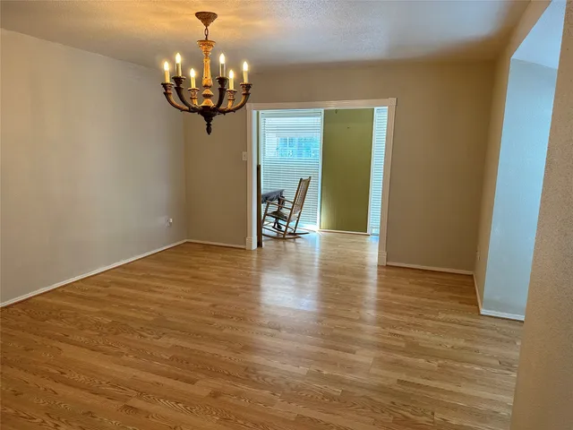 a view of a livingroom with wooden floor and a chandelier
