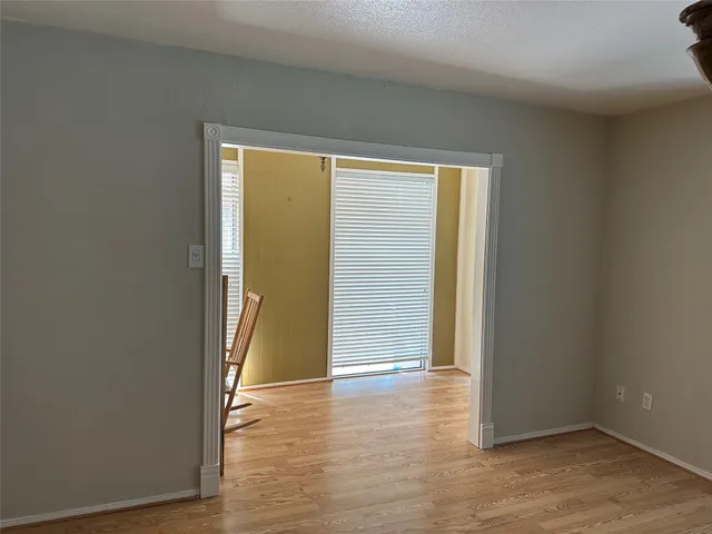 an empty room with wooden floor and entrance