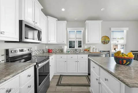 a kitchen with stainless steel appliances granite countertop a sink dishwasher stove and cabinets