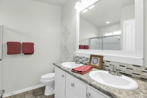 a bathroom with a granite countertop sink a toilet and a mirror