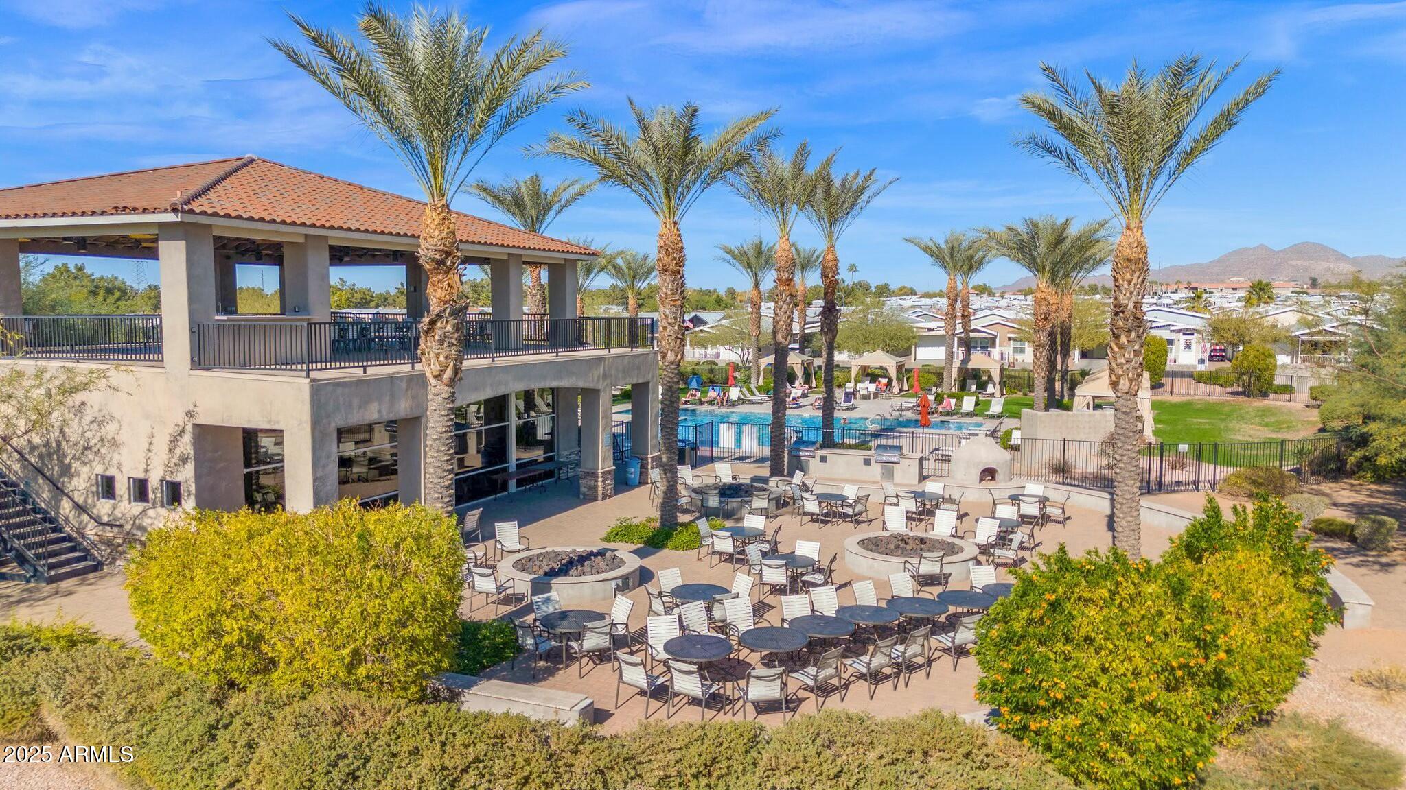 650 North Hawes Road, Unit 3505 Mesa, AZ 85207 - Photo 35 of 46 a view of a swimming pool with a lawn chairs under palm trees