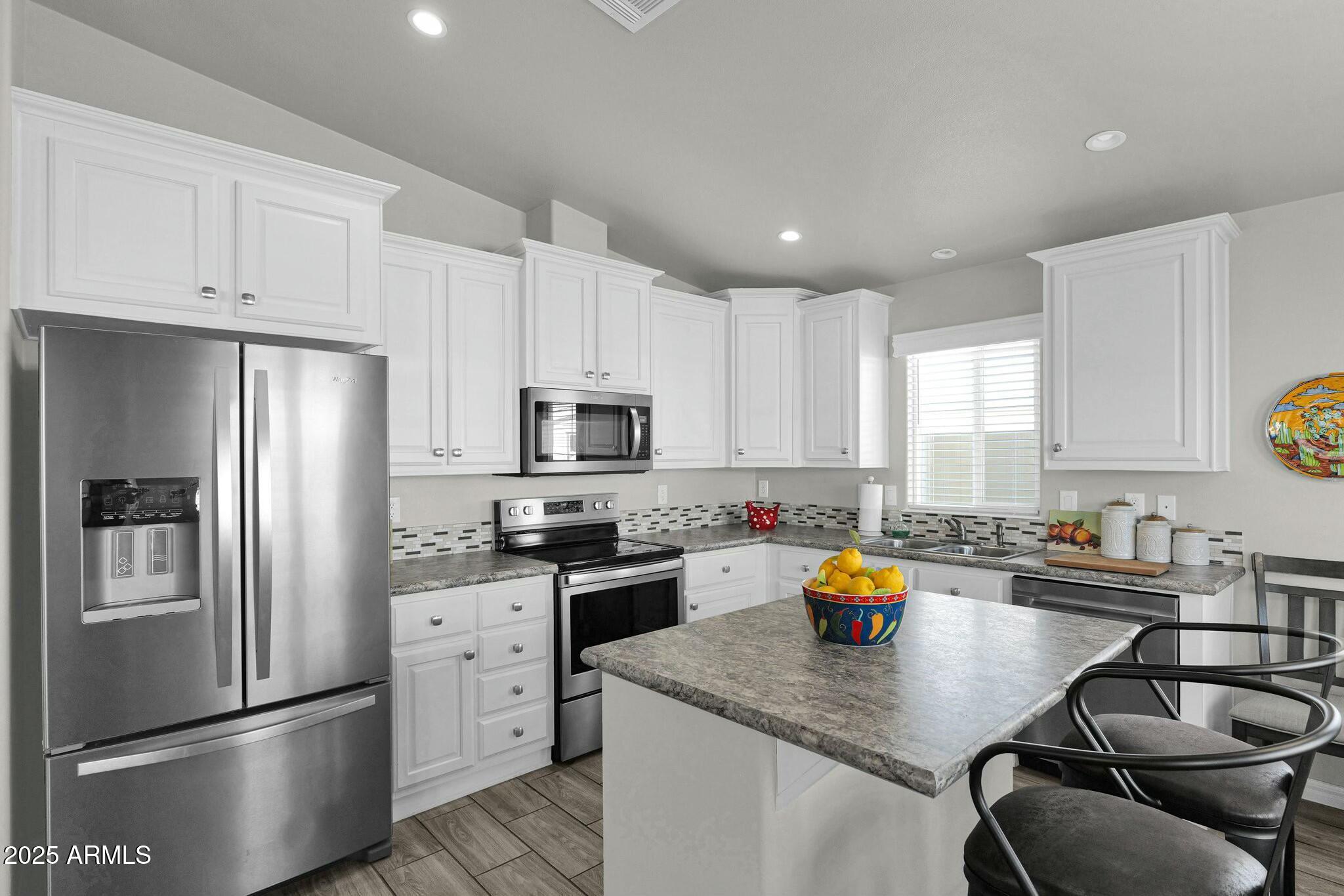650 North Hawes Road, Unit 3505 Mesa, AZ 85207 - Photo 10 of 46 a kitchen with stainless steel appliances granite countertop a sink a stove a refrigerator a stove a dining table and chairs