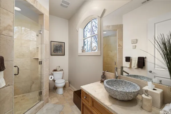 a bathroom with a granite countertop toilet sink and mirror
