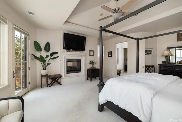 a spacious bedroom with a bed and a flat screen tv