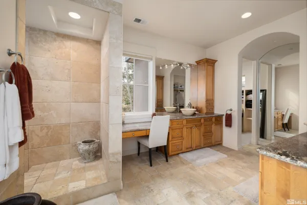a large white bathroom with a tub a sink and a large mirror