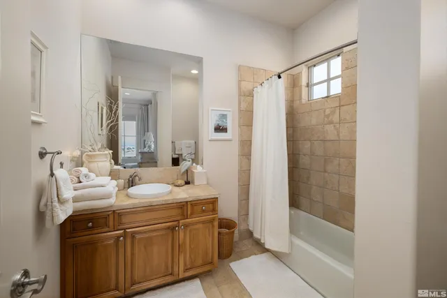 a bathroom with a double vanity sink mirror and shower