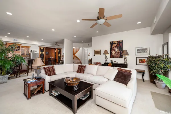 a living room with furniture kitchen view and a potted plant