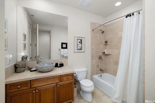 a bathroom with a granite countertop sink a toilet and shower