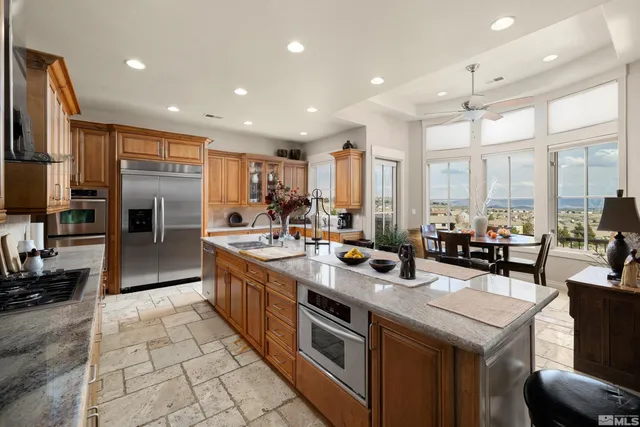 a kitchen with stainless steel appliances granite countertop a sink and a refrigerator