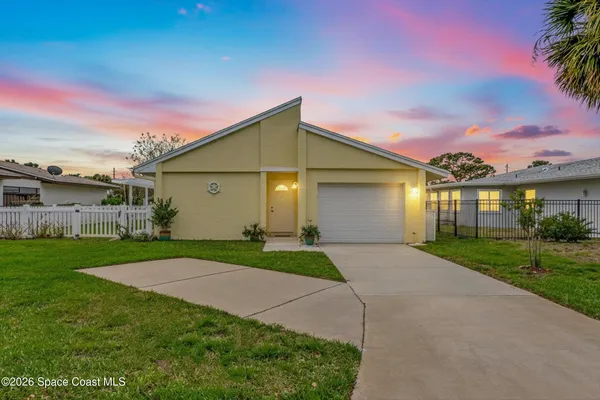 a view of a big house with a big yard and potted plants