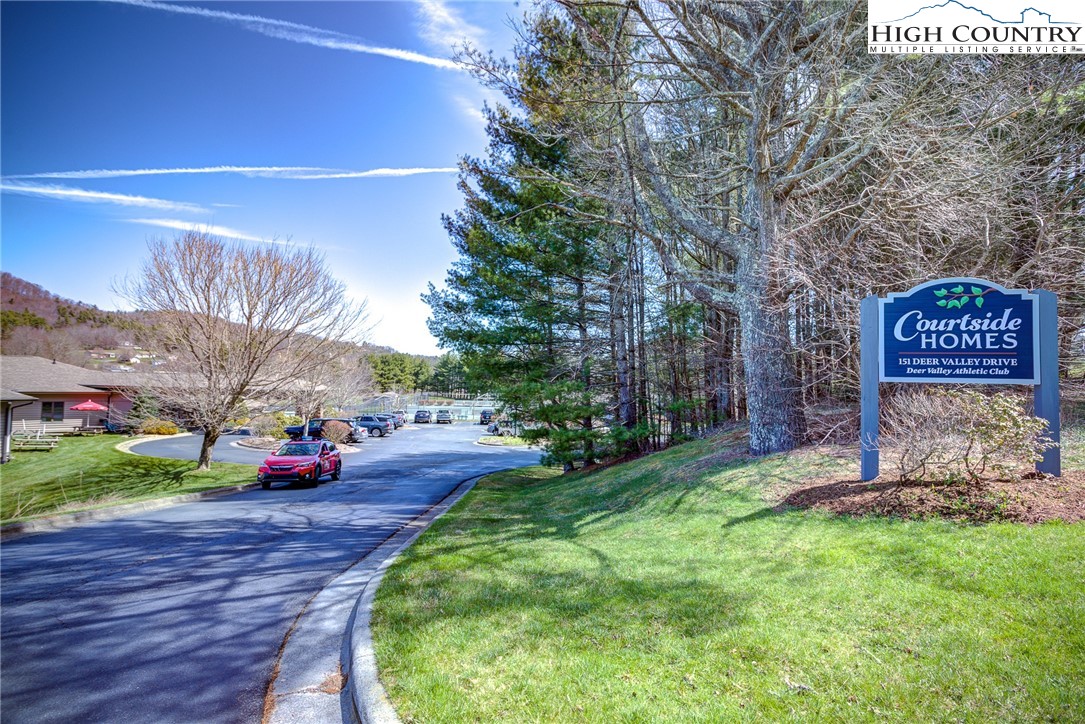 151 Deer Valley Drive, Unit 234 Boone, NC 28607 - Photo 20 of 22 a sign board with flower plants and large trees