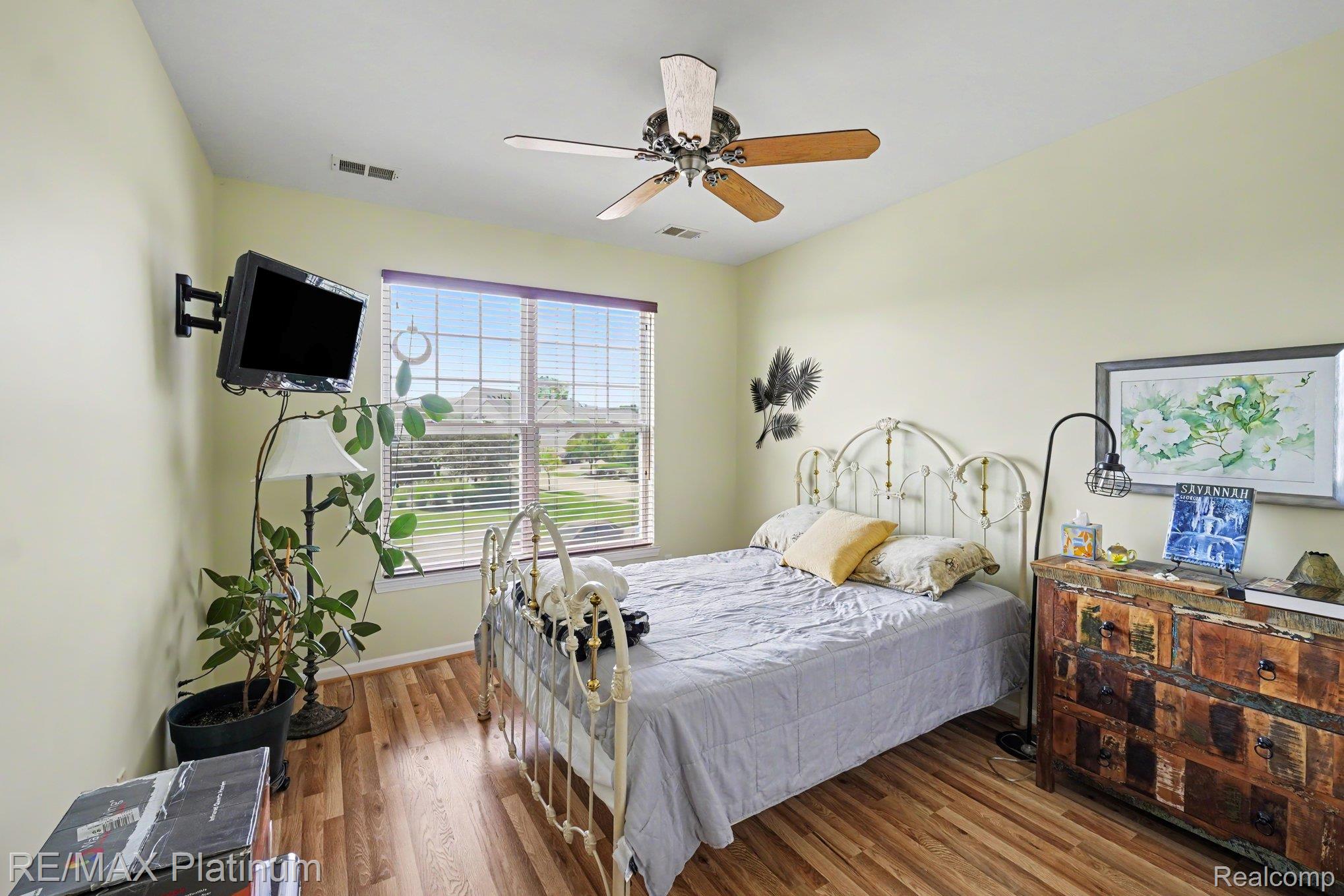 10217 Crossview Trail Howell, MI 48855 - Photo 14 of 26 Room featuring wood-finish flooring, a ceiling fan with light fixture, and a window with blinds