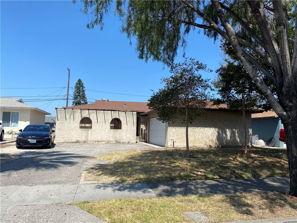 1321 North Devonshire Road Anaheim, CA 92801 - Photo 1 of 1 a white house that has a tree in front of it