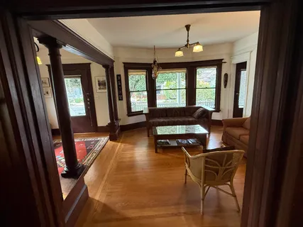 a view of a a dining room with furniture window and wooden floor