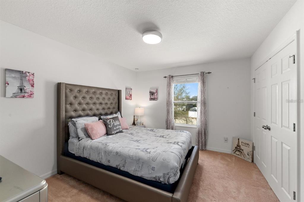 754 Andalusia Loop Davenport, FL 33837 - Photo 13 of 28 a bedroom with a large bed and a window