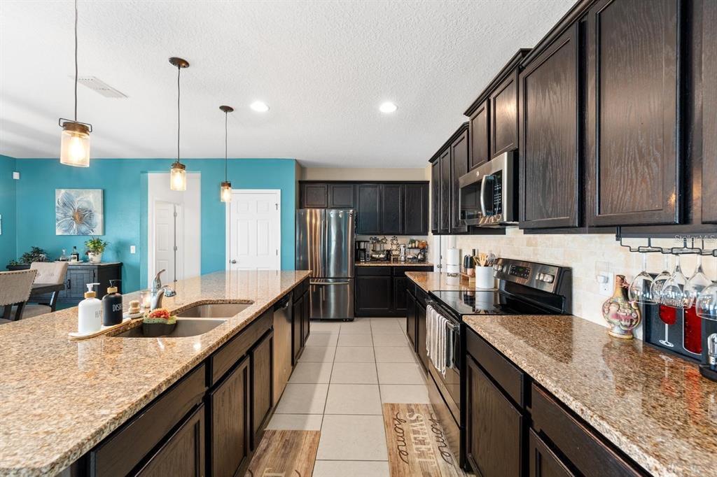 754 Andalusia Loop Davenport, FL 33837 - Photo 4 of 28 a large kitchen with granite countertop lots of counter top space