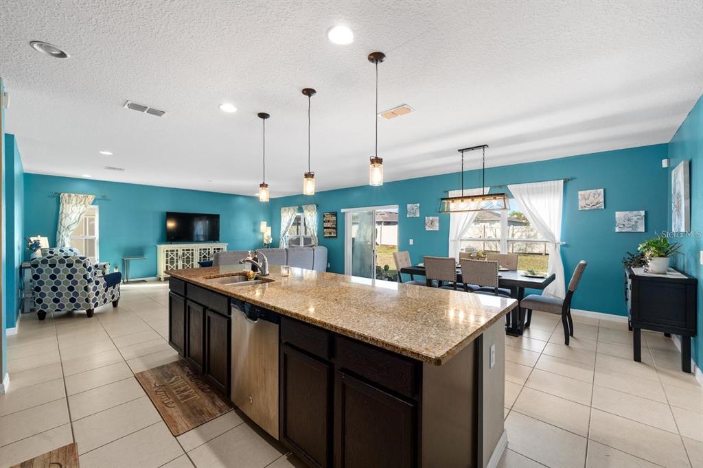 754 Andalusia Loop Davenport, FL 33837 - Photo 5 of 28 a kitchen with a stove a kitchen island a sink and a refrigerator