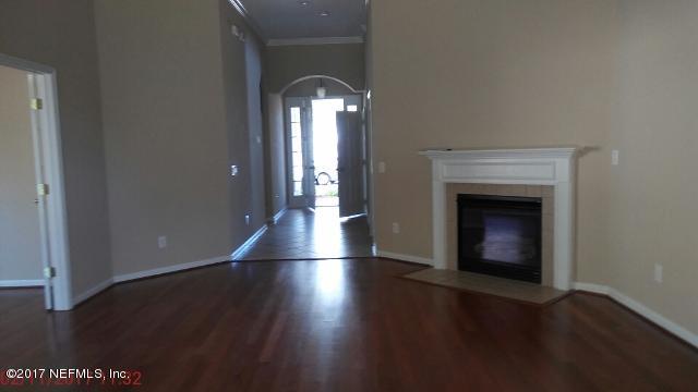 3421 South Saxxon Road St. Augustine, FL 32092 - Photo 2 of 13 an empty room with wooden floor fireplace and windows