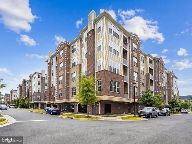 a view of building with lot of cars parked in front of it