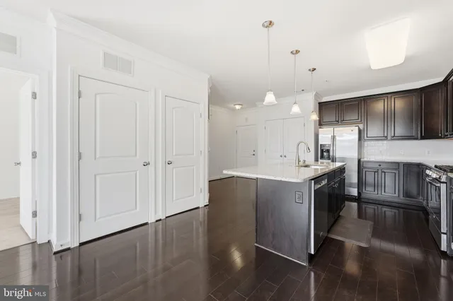 a kitchen with kitchen island white cabinets and stainless steel appliances