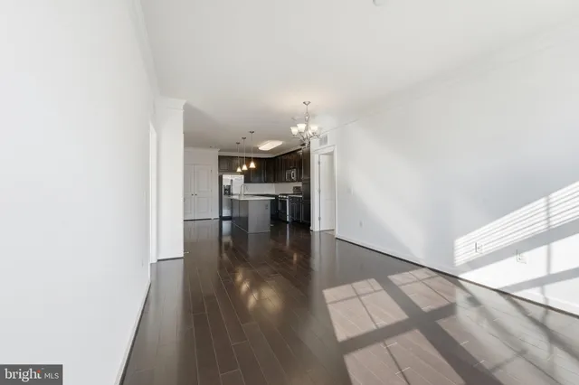 a hallway with wooden floor table and chairs